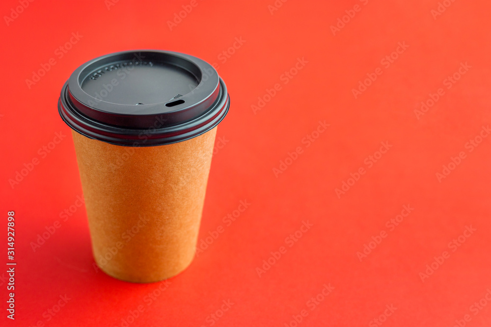 Paper coffee cup for takeaway drinks on red background with copy space. Mockup brown paper cup Paper coffee cup for takeaway drinks on red background with copy space. Mockup brown paper cup