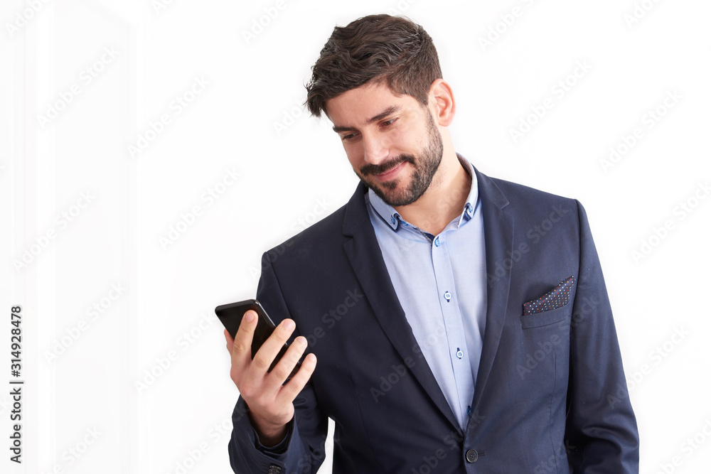 Smiling businessman using his mobile phone while standing at isolated white background Smiling businessman using his mobile phone while standing at isolated white background