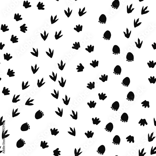 Naklejka Seamless repeat pattern with different shape black dinosaur foot prints tracks trails on a white background