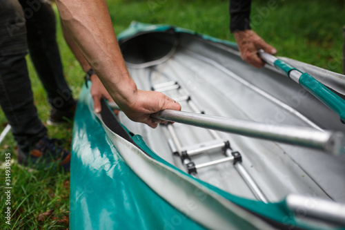 The process of assembling and repairing kayaks: metal skeleton, PVC skin, wooden and aluminum frames. Male hands assemble the canoes and paddle boating.