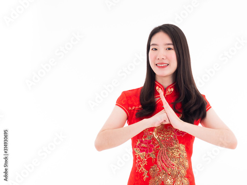 Asian pretty young girl smiling and saying hello with hand gesture by culture Chinese style with wear traditional red cheongsam or qipao dress included golden dragon detail on fashion cloth portrait photo