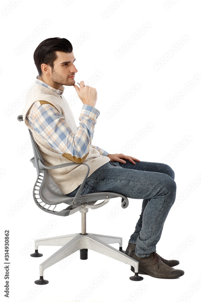 Side view of young man in swivel chair