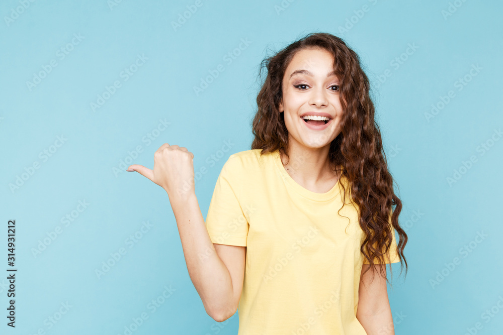 Young happy woman pointing to theleft by her finger Young happy woman pointing to theleft by her finger
