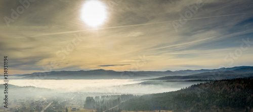 Fog in mountains before sunrise, mountain valley with clouds. View to mountains of the Carpathians