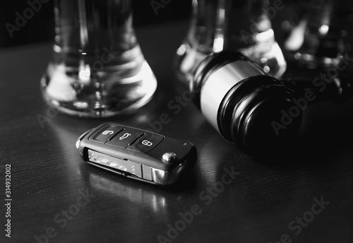 Drinking and driving concept. Car key on a wooden table, pub background photo