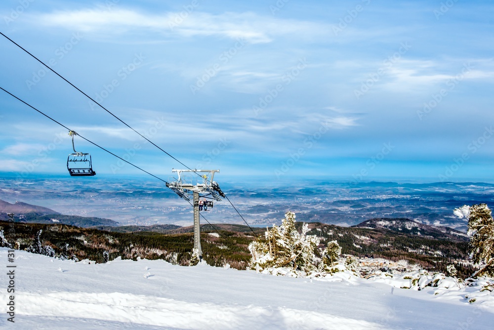 Panoramic view of an alpine mountainside with ski lift Panoramic view of an alpine mountainside with ski lift