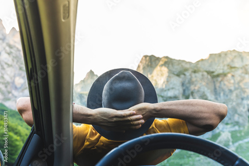 Fotografie Man Laid Down on the Car Bonnet While Enjoy the Views of Nature.