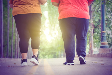 Unidentified legs of fat people jogging at park