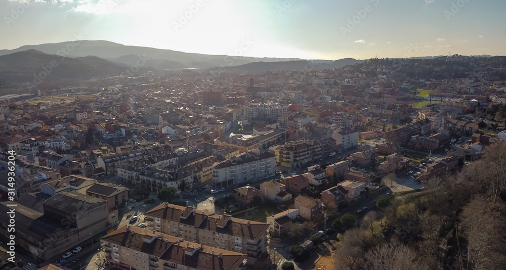 Aerial view of Sant Celoni city in Catalonia. Dusk early morning shot against the sun.