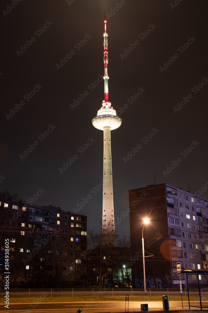 Obraz premium Vilnius TV Tower, Lithuania colored with white light, night, with soviet buildings, vertical