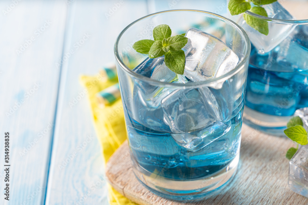Blue lemonade in glasses on wood background, copy space Blue lemonade in glasses on wood background, copy space
