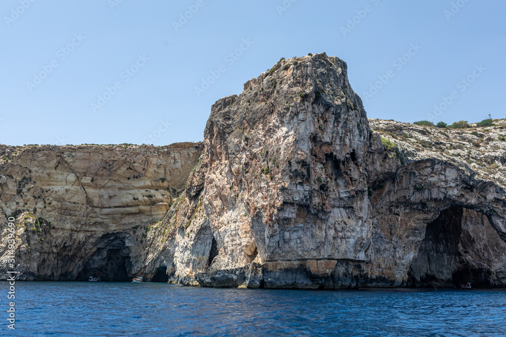 rocks in the sea. Mountain slopes on the background of the sea shore. Seascape with mountain landscape. Photo of a sea landscape.