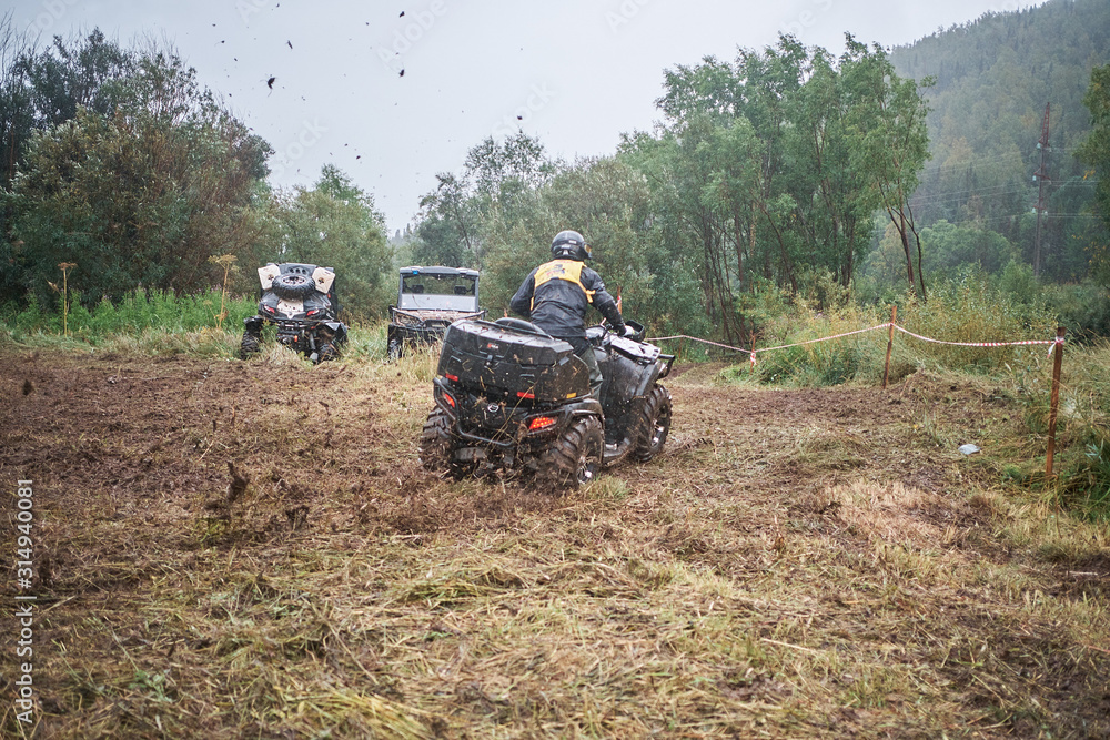 Obraz premium Quad rider jumping on a muddy forest trail.