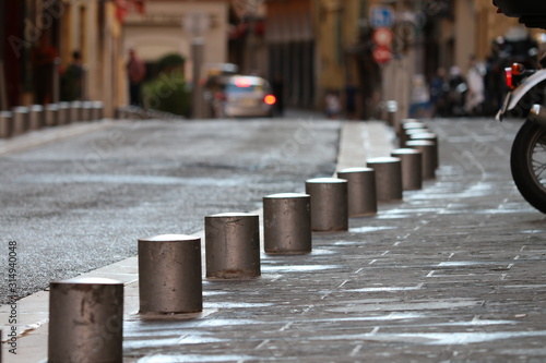Fototapeta Naklejka Na Ścianę i Meble -  Small bumper posts  on the street . Sidewalk post railing.  Pedestrian safety posts. Blured background