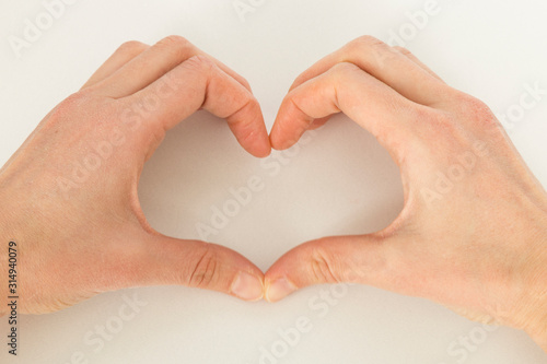 the woman make heart shape with her hand.