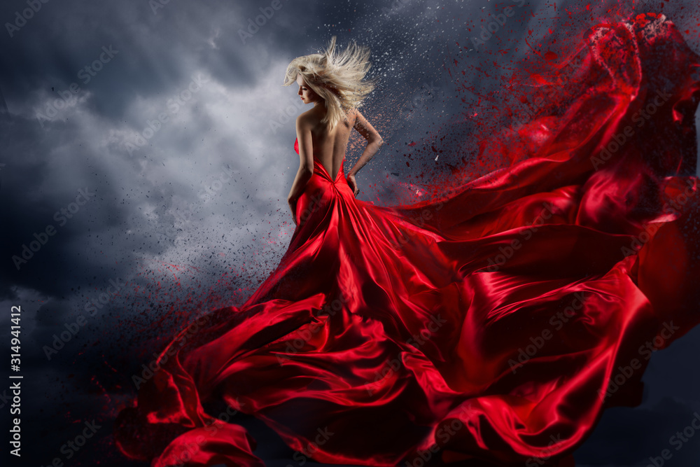 Naklejka premium Kobieta w czerwonej sukience tańczy nad burzowym niebem, trzepotliwy materiał sukni latający jak plusk