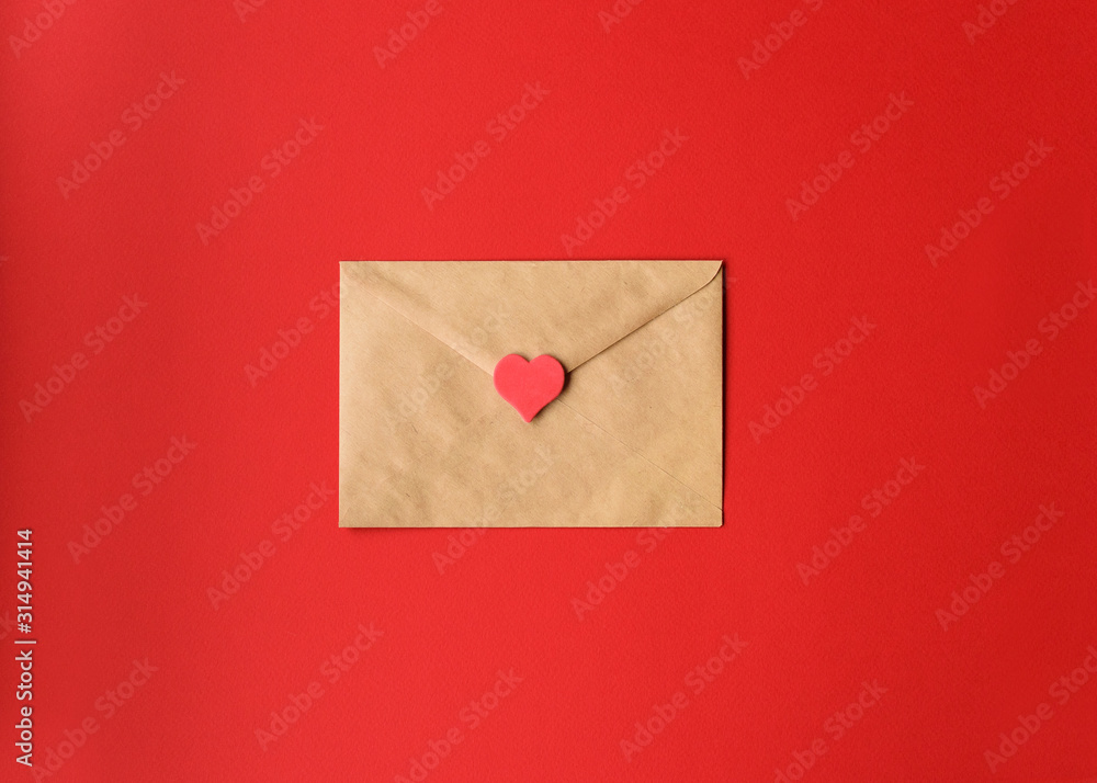 St. Valentine's love letter of craft paper with red heart on red background with copy space. Horizontal. St. Valentine's love letter of craft paper with red heart on red background with copy space. Horizontal.
