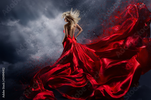 Foto Woman in Red Dress Dance over Storm Sky, Gown Fluttering Fabric Flying as Splash