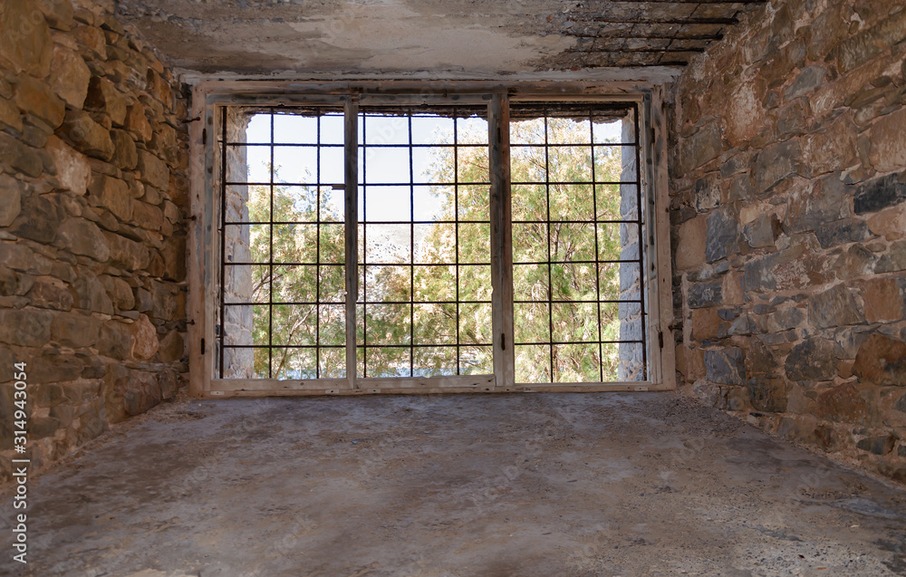 view from an old building through a window with metal bars view from an old building through a window with metal bars