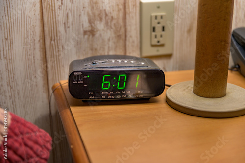 Papier peint A nightstand with a tabletop lamp, alarmclock, and touchtone phone