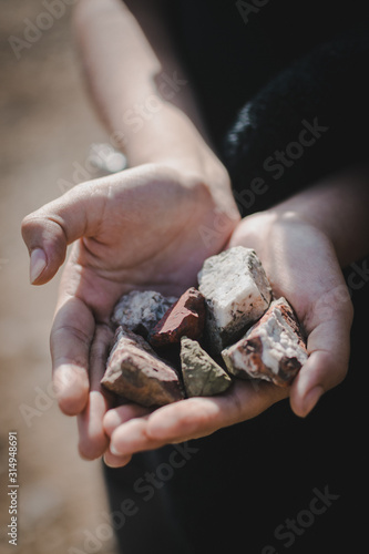 pequeñas rocas de colores sostenidas por manos de mujer 