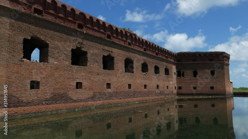 Steady shot of the ruins of an old fort reflected in the waters of the moat