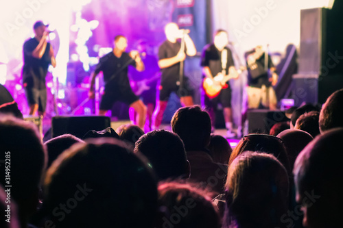 A crowd of people watching a musical group performing on stage