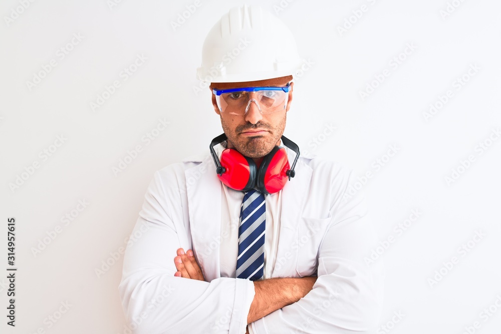 Young chemist man wearing security helmet and headphones over isolated background skeptic and nervous, disapproving expression on face with crossed arms. Negative person. Young chemist man wearing security helmet and headphones over isolated background skeptic and nervous, disapproving expression on face with crossed arms. Negative person.