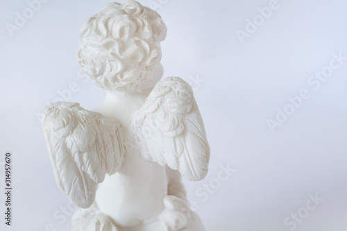 angel wings statue turned away back on white background