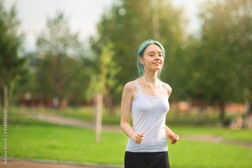 beautiful young woman with a slim figure is jogging in the summer in the park beautiful young woman with a slim figure is jogging in the summer in the park