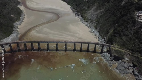 4K summer day aerial video: Kaaimans River Railway Bridge, white sand beach, Kaaimans River mouth. Bridge is located near Wilderness, seaside holiday resort, Garden Route, Western Cape, South Africa photo