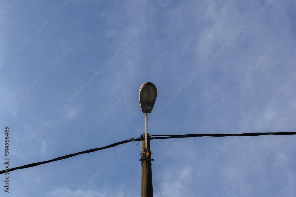 street lamp turned off by day over blue sky street lamp turned off by day over blue sky