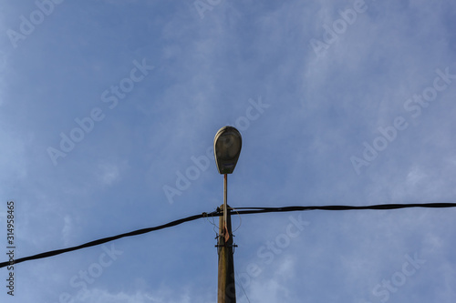 street lamp turned off by day over blue sky © ZAIRIAZMAL