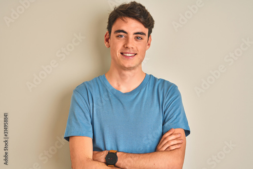 Teenager boy wearing casual t-shirt standing over isolated background happy face smiling with crossed arms looking at the camera Fototapeta