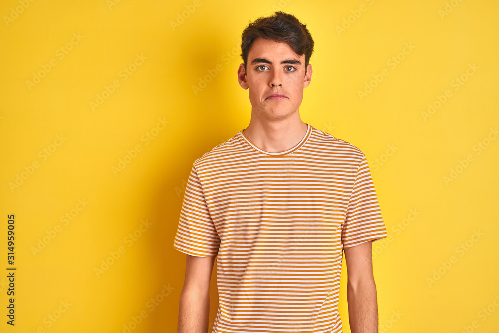 Teenager boy wearing yellow t-shirt over isolated background depressed and worry for distress, crying angry and afraid. Sad expression. Teenager boy wearing yellow t-shirt over isolated background depressed and worry for distress, crying angry and afraid. Sad expression.