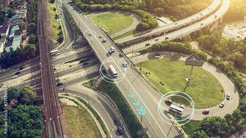 Autonomous Self Driving Cars Concept. Aerial view of cars and buses moving on city intersection and Artificial Intelligence scans road with sensors and control vehicles in traffic. Future © DedMityay