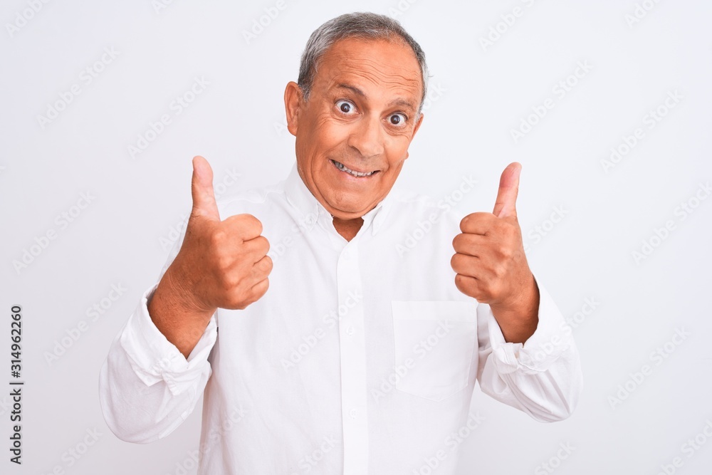 Senior grey-haired man wearing elegant shirt standing over isolated white background success sign doing positive gesture with hand, thumbs up smiling and happy. Cheerful expression and winner gesture. Senior grey-haired man wearing elegant shirt standing over isolated white background success sign doing positive gesture with hand, thumbs up smiling and happy. Cheerful expression and winner gesture.