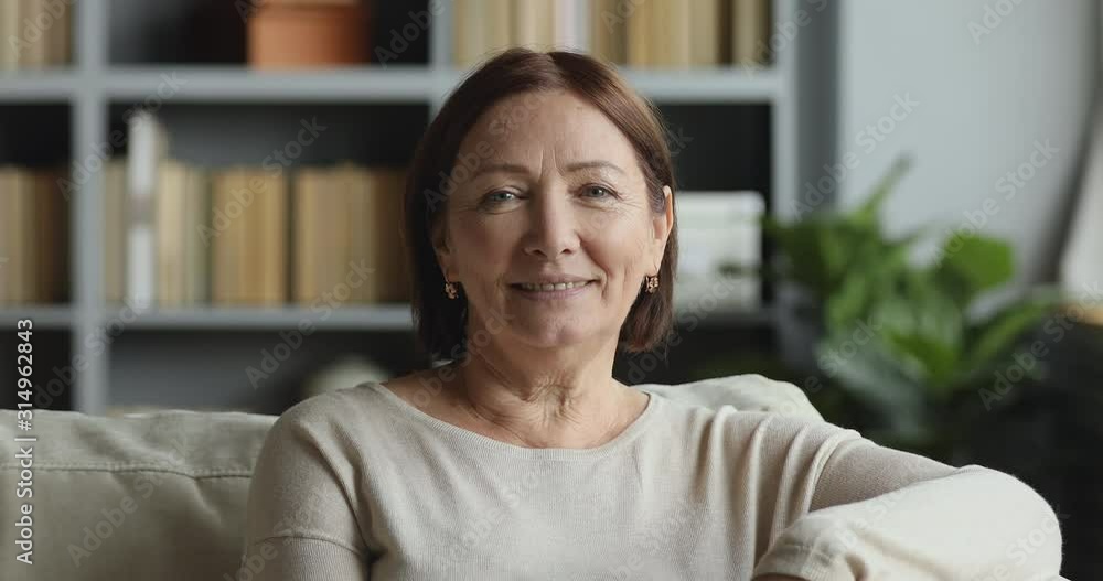 Smiling older adult lady looking at camera posing at home Smiling older adult lady looking at camera posing at home