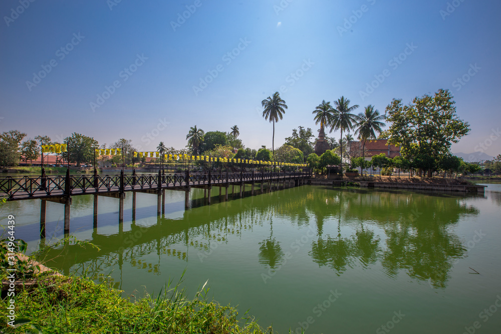 Background of Wat Traphang Thong, which is located in the middle of the water and has a wooden bridge, which is used to organize ceremonies (Loi Krathong, New Year) in Sukhothai province, Thailand. Background of Wat Traphang Thong, which is located in the middle of the water and has a wooden bridge, which is used to organize ceremonies (Loi Krathong, New Year) in Sukhothai province, Thailand.