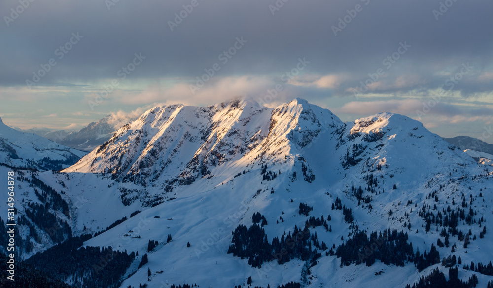 Mountain portrait Saalbach sunset clouds perfect blue sky purple light snowy mountainscape