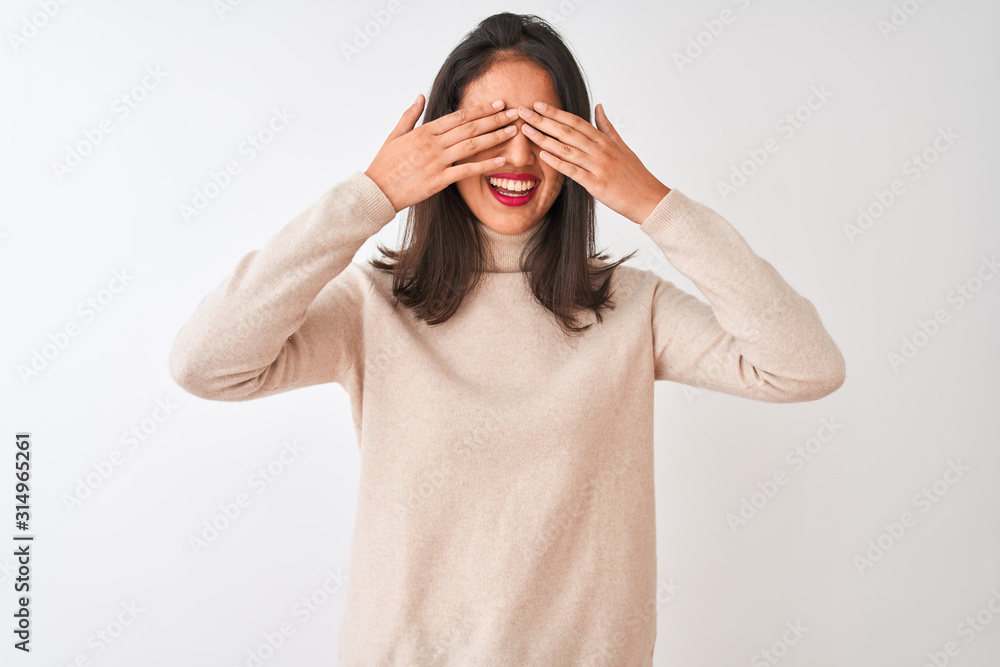 Beautiful chinese woman wearing turtleneck sweater standing over isolated white background covering eyes with hands smiling cheerful and funny. Blind concept. Beautiful chinese woman wearing turtleneck sweater standing over isolated white background covering eyes with hands smiling cheerful and funny. Blind concept.