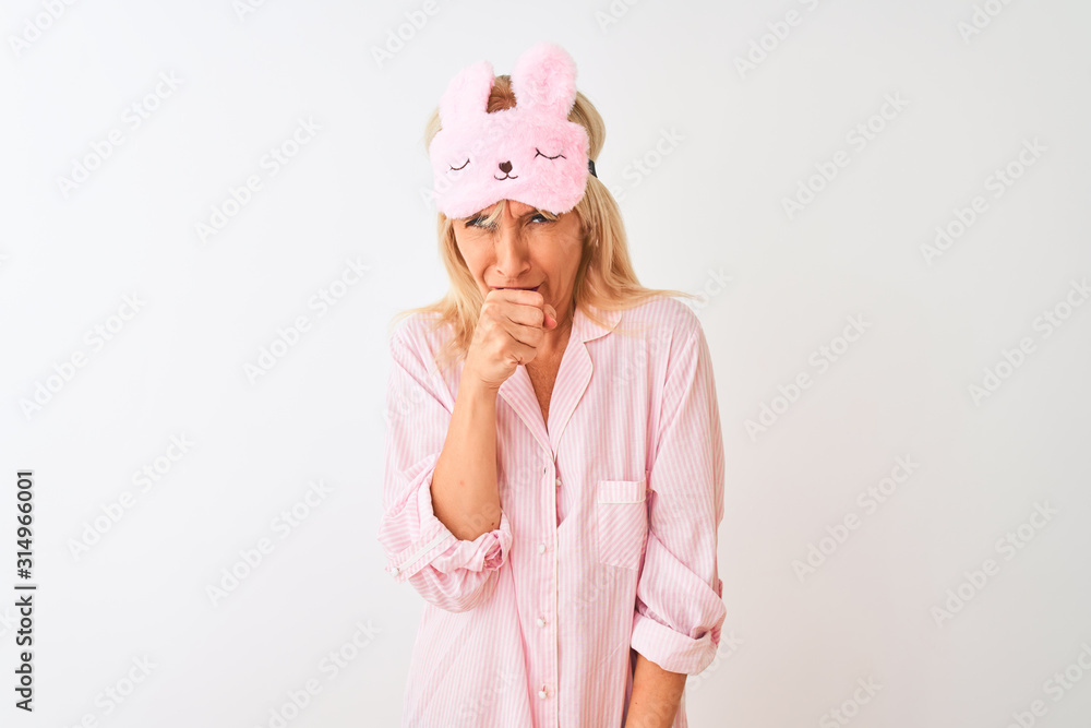 Middle age woman wearing sleep mask and pajama over isolated white background feeling unwell and coughing as symptom for cold or bronchitis. Healthcare concept. Middle age woman wearing sleep mask and pajama over isolated white background feeling unwell and coughing as symptom for cold or bronchitis. Healthcare concept.