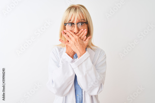 Fototapeta Naklejka Na Ścianę i Meble -  Middle age scientist woman wearing glasses standing over isolated white background shocked covering mouth with hands for mistake. Secret concept.