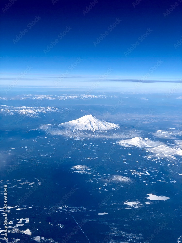 Aerial view of snow covered peak from the window of an airplane