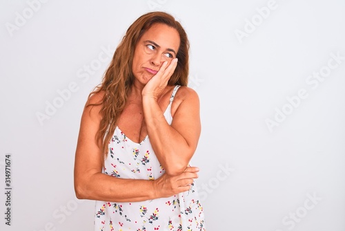 Middle age mature woman standing over white isolated background thinking looking tired and bored with depression problems with crossed arms.