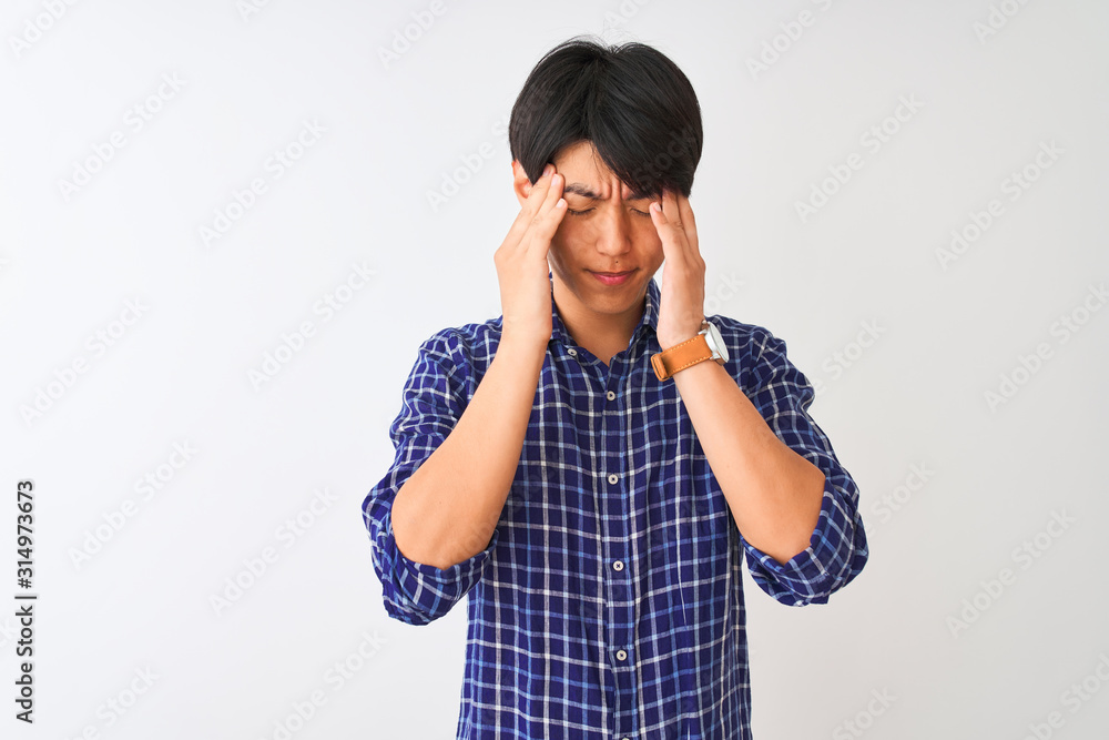 Young chinese man wearing casual blue shirt standing over isolated white background with hand on head for pain in head because stress. Suffering migraine. Young chinese man wearing casual blue shirt standing over isolated white background with hand on head for pain in head because stress. Suffering migraine.