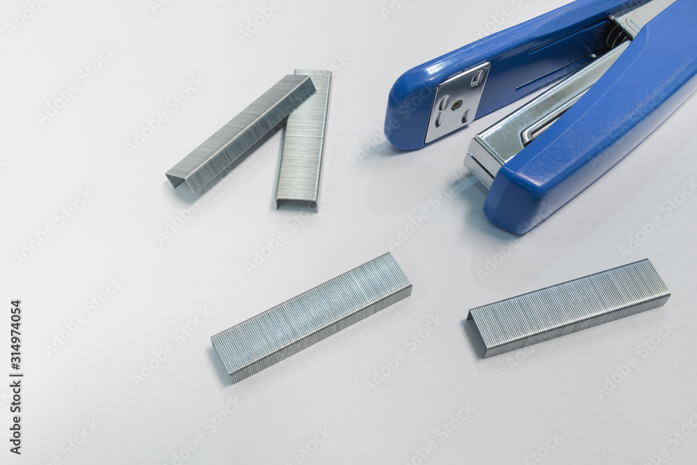 Stapler and staples placed on white paper in the office. Stapler and staples placed on white paper in the office.