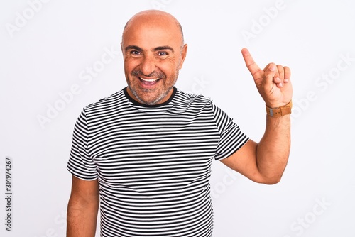 Middle age handsome man wearing striped navy t-shirt over isolated white background showing and pointing up with finger number one while smiling confident and happy.