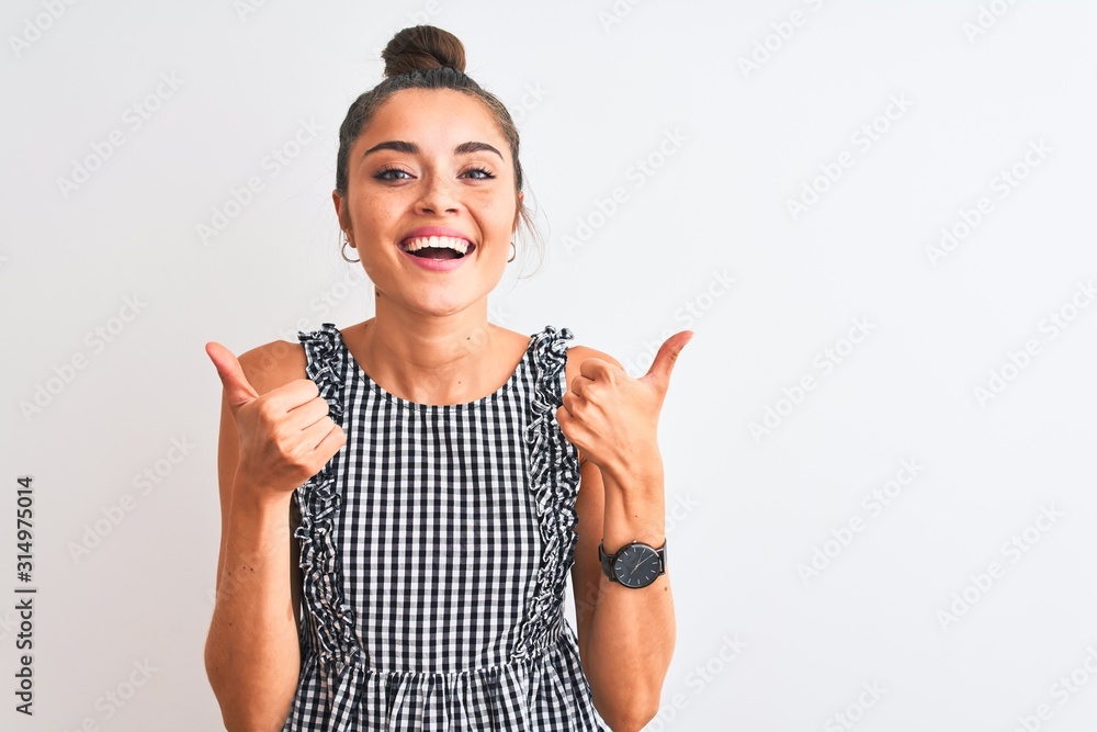 Beautiful woman with bun wearing casual dresss standing over isolated white background success sign doing positive gesture with hand, thumbs up smiling and happy. Cheerful expression and winner Beautiful woman with bun wearing casual dresss standing over isolated white background success sign doing positive gesture with hand, thumbs up smiling and happy. Cheerful expression and winner
