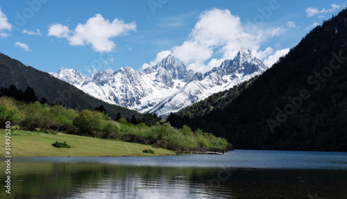 Nature landscape, green valley with snow mountain and lake in summer